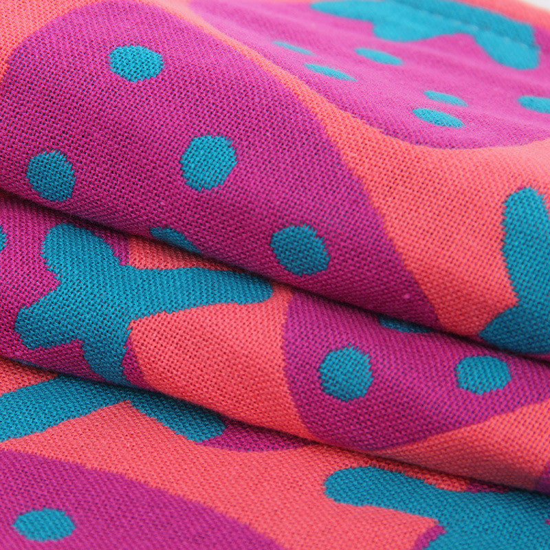 Close up of pink and teal cotton hand or face towel with strawberry pattern