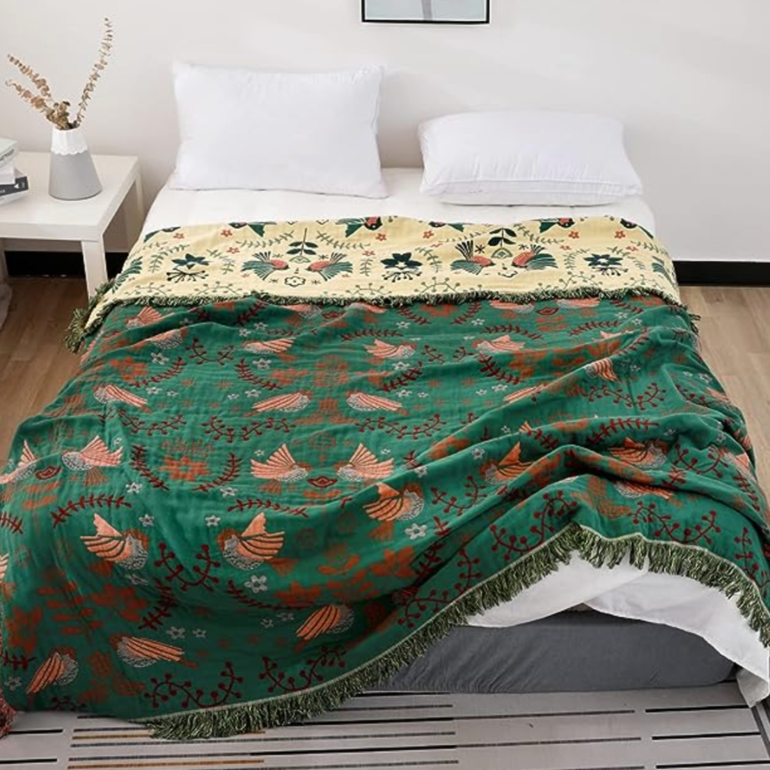 Green cotton blanket with birds flowers on bed