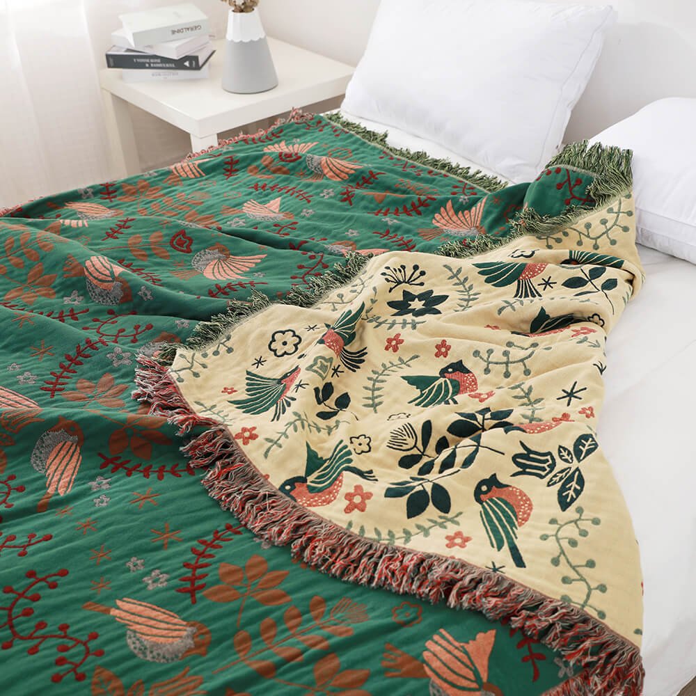 Green cotton blanket with birds flowers on bed