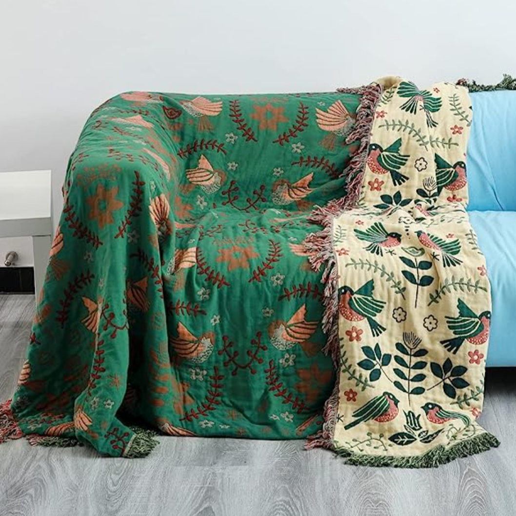 Green cotton blanket with birds flowers on couch