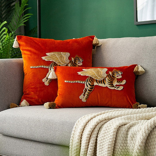 Orange velvet cushions with embroidered flying tiger and tassels on corner