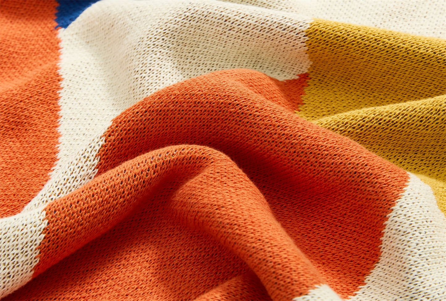 Close up of warm summer leaves cotton knitted blanket on bed