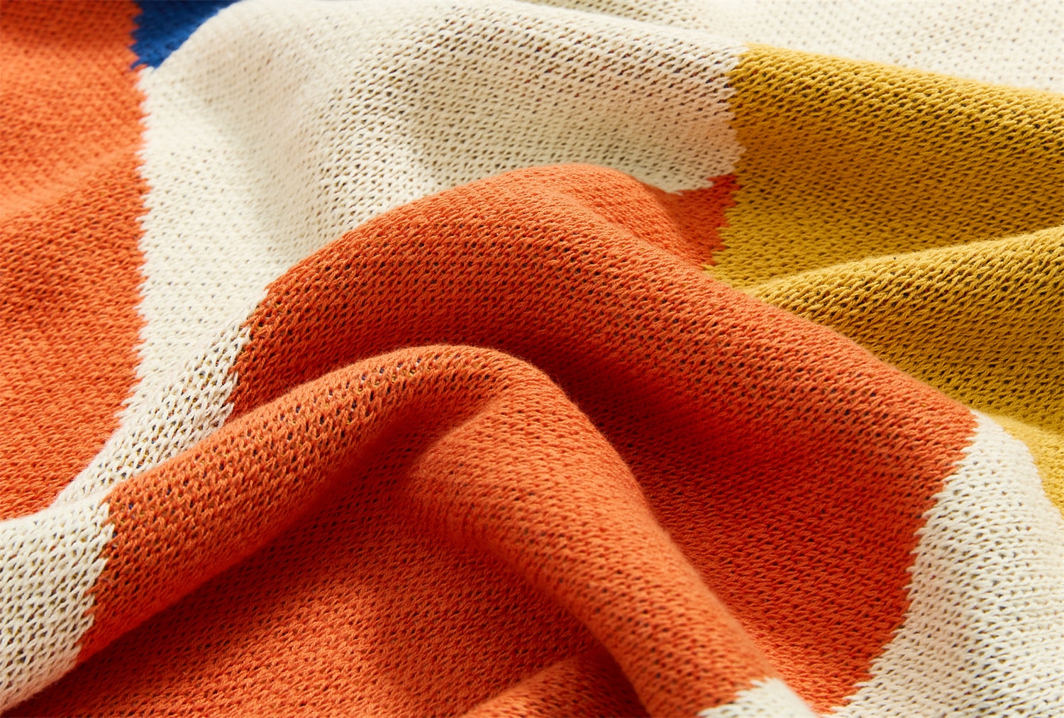 Close up of warm summer leaves cotton knitted blanket on bed