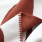 Close up of earthy red and white knitted blanket