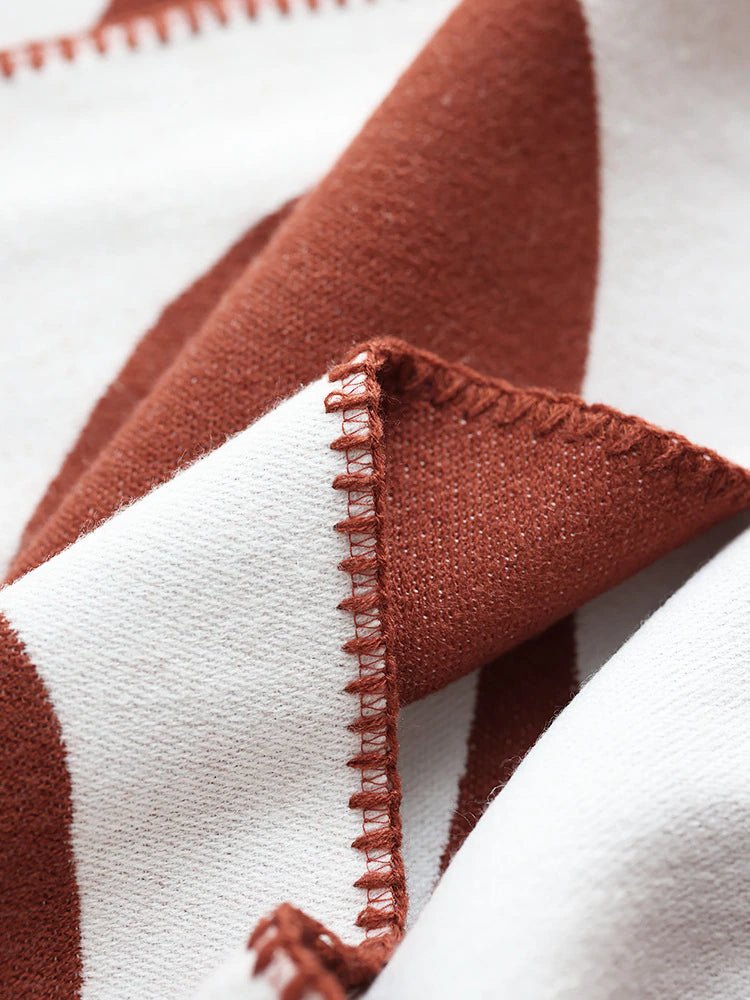 Close up of earthy red and white knitted blanket