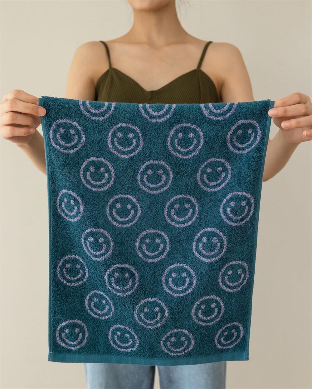 Green purple smiley face hand towel