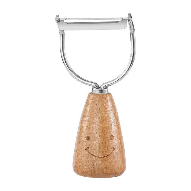 Stainless steel vegetable peeler with wooden handle and smiley face