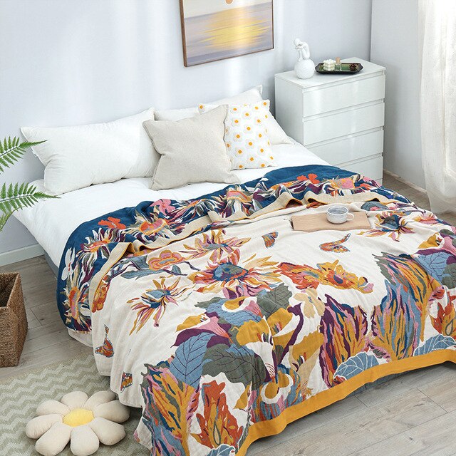 Colourful cotton garden oasis throw blanket with tropical flowers and butterflies on bed