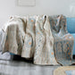 Cream throw blanket with abstract pattern of earthy blues and orange