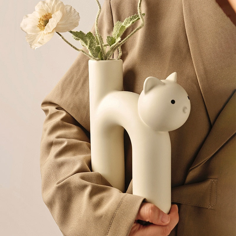 Cream ceramic cat vase being held under arm