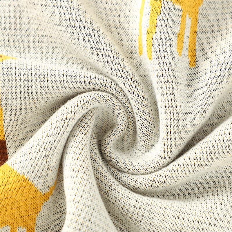 Close up of cream cotton knit blanket with giraffes