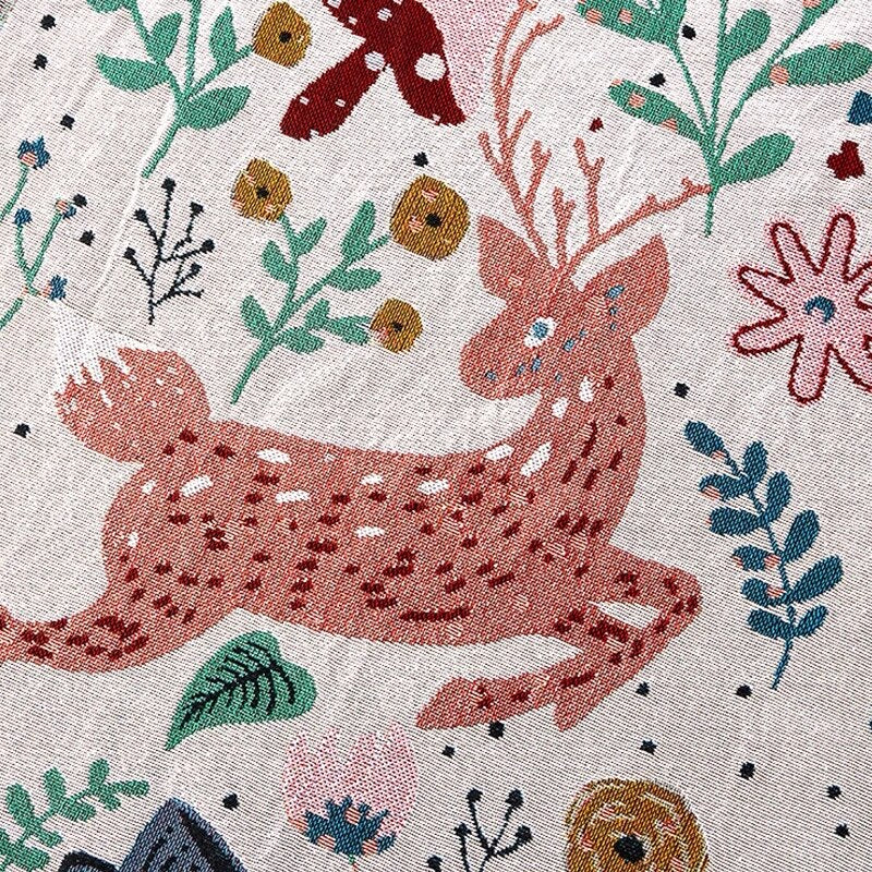 Close up of whimsical nordic garden blanket featuring deer and flowers