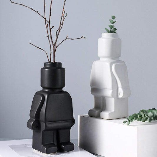 A black and a white lego man ceramic vase