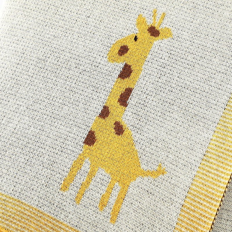 Close up of cream cotton knit blanket with giraffes