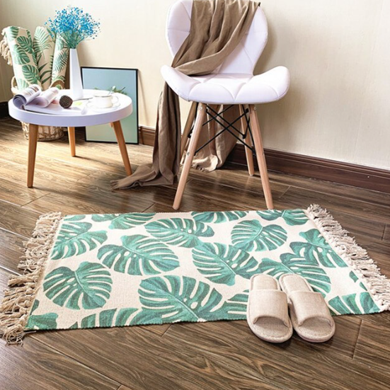 Palm leaf rug with fringed edge on floor with  slippers chair and table