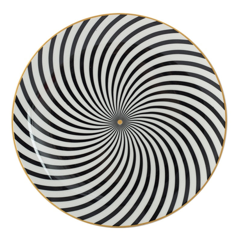 Black and white swirl patterned plate with yellow gold centre and edge