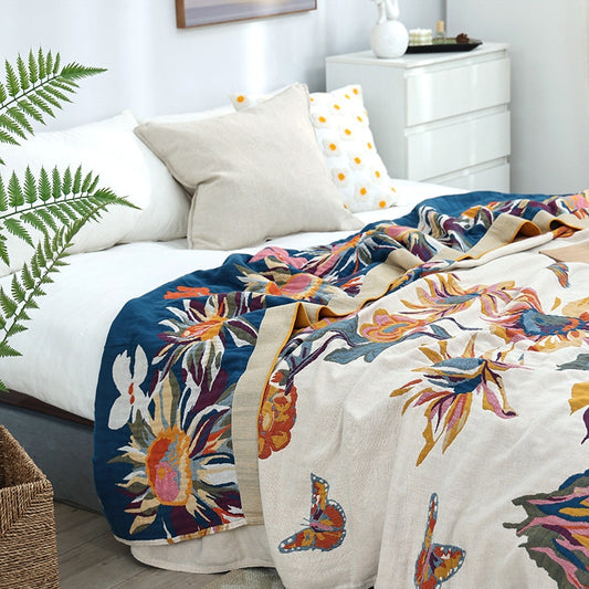 Colourful cotton garden oasis throw blanket on bed with tropical flowers and butterflies