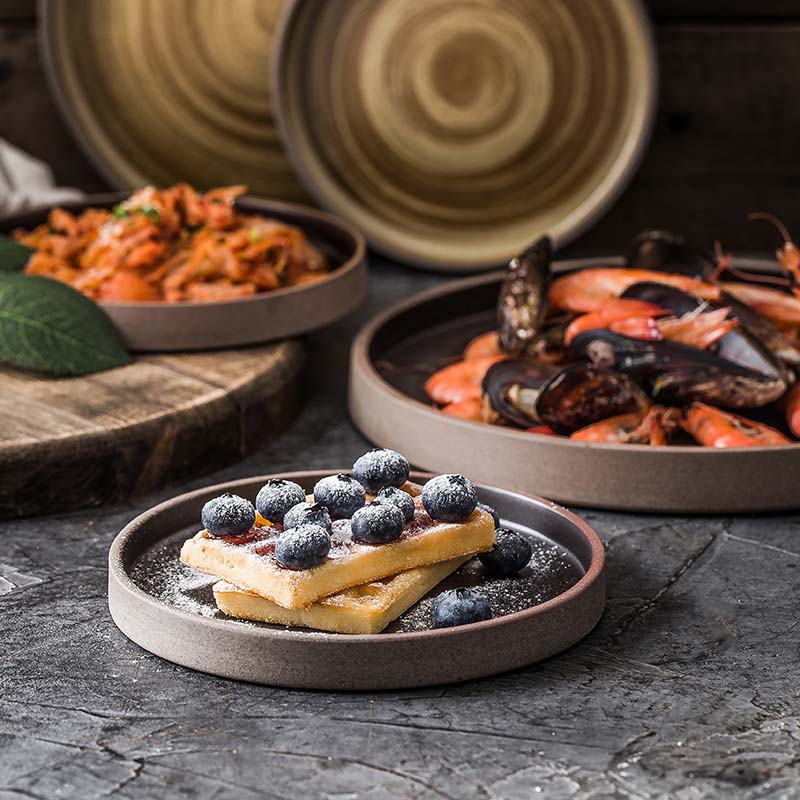 Dessert and food on charcoal plates with rim