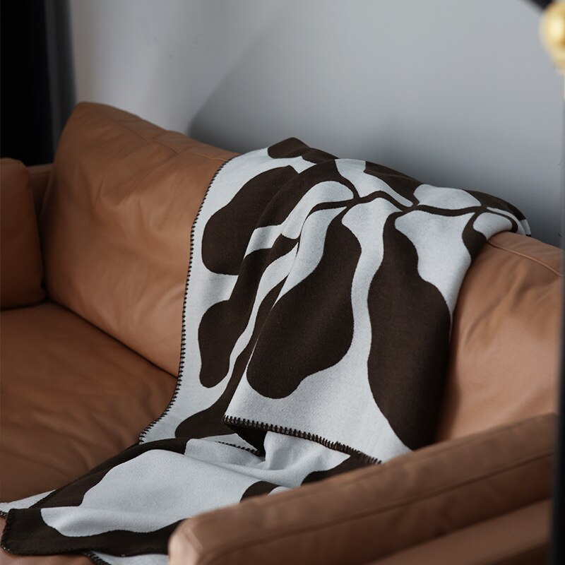 Chocolate brown and white knitted blanket on sofa