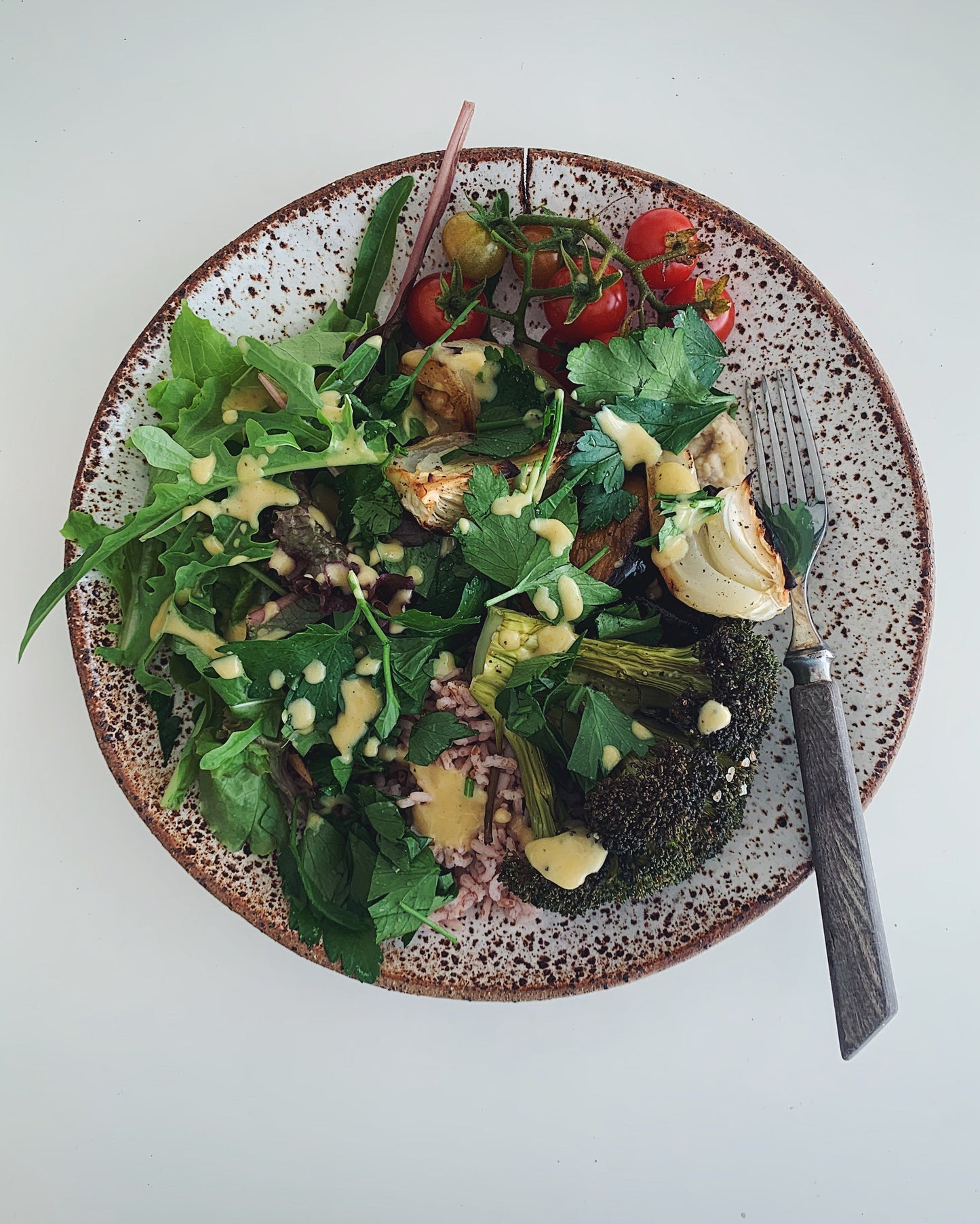 Speckled cream and brown handmade ceramic plate with salad