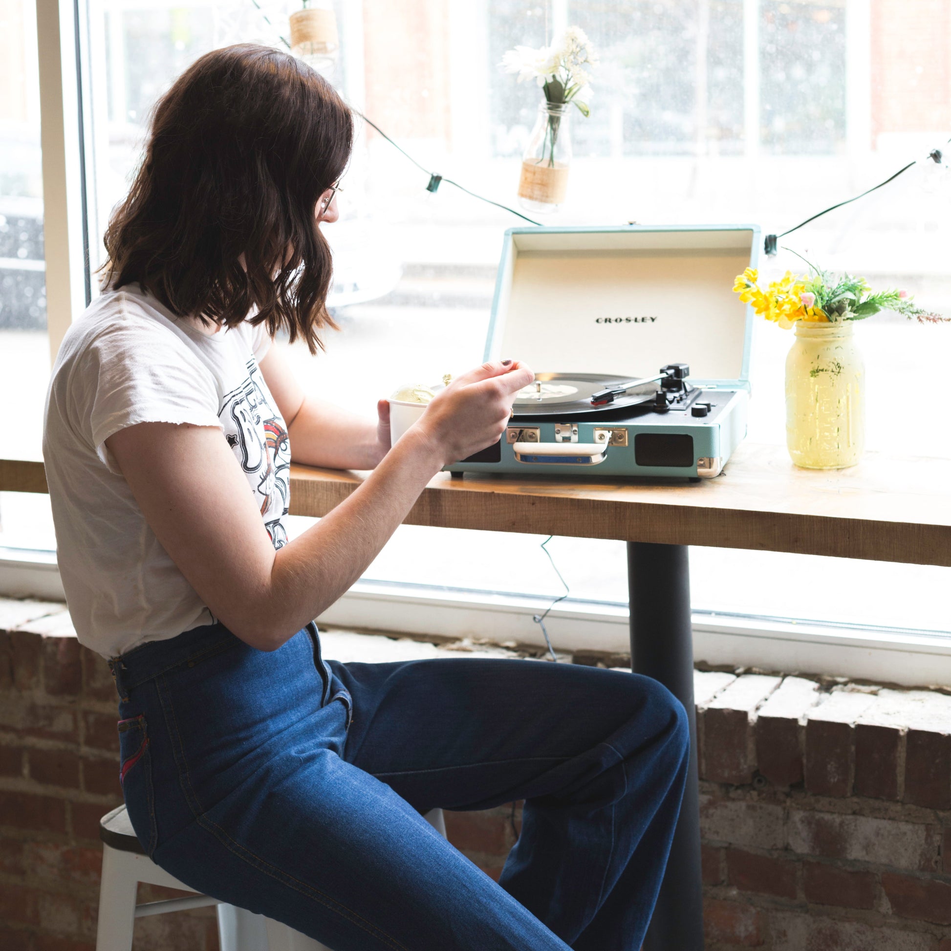 Woman with Crosley Cruiser turquoise Bluetooth portable turntable