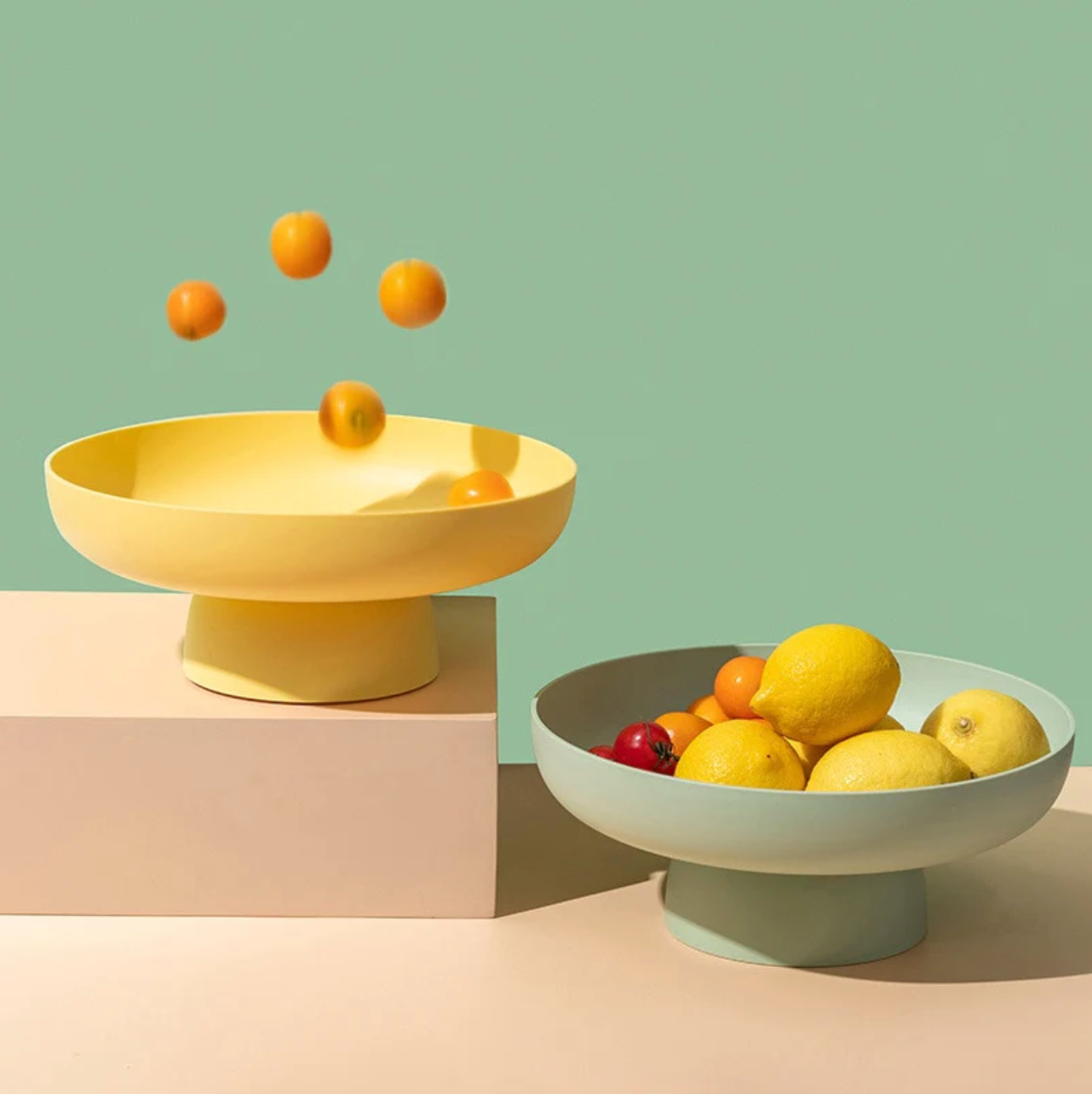 Yellow and green rounded elevated bowls with fruit