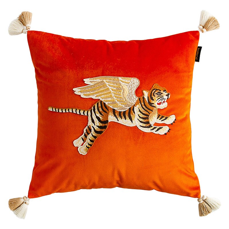 Orange velvet cushion with embroidered flying tiger and tassels on corners