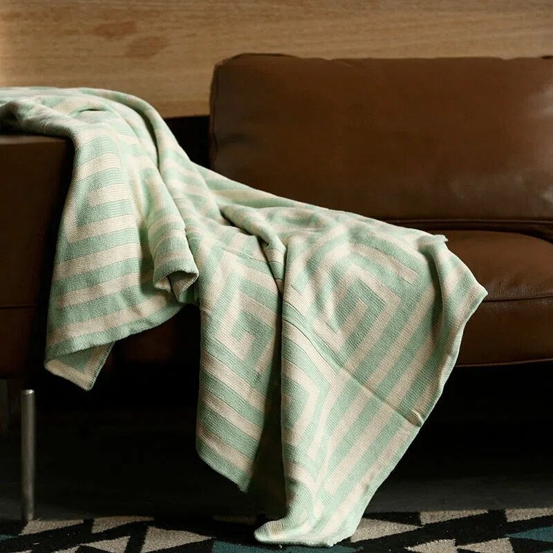 Mint green and cream geometric throw blanket on lounge