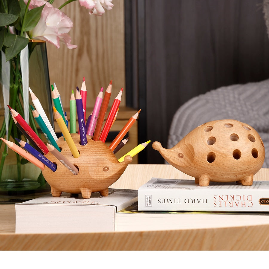 Two timber hedgehog pen holders with pencils and books