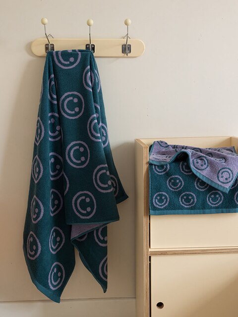 Green purple smiley face towel hanging up