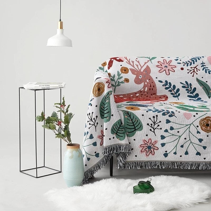 Whimsical nordic garden blanket featuring deer and flowers with fringed edge