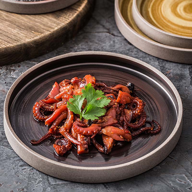 Food on charcoal plate with rim