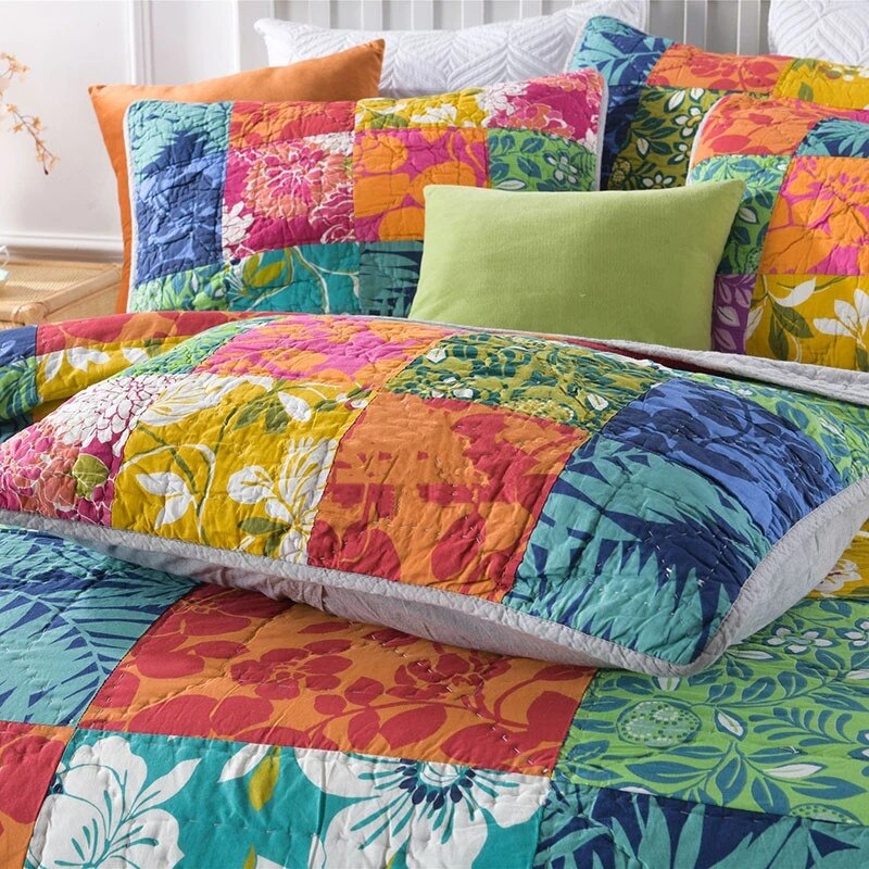 Close up of colourful patchwork quilt and pillow cases on bed 