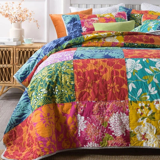 Close up of colourful patchwork quilt and pillow cases on bed 