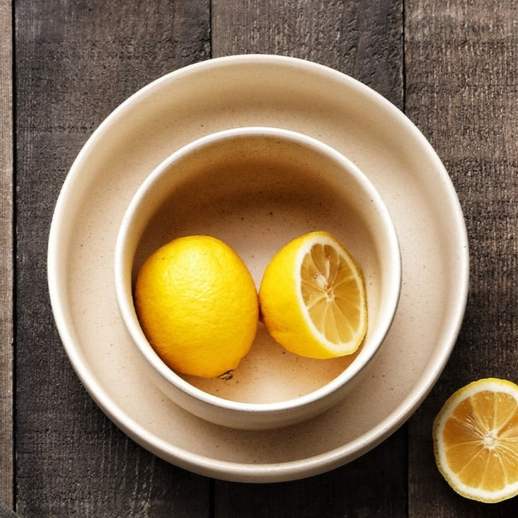 Top view of cream bowls on timber surface with lemons 