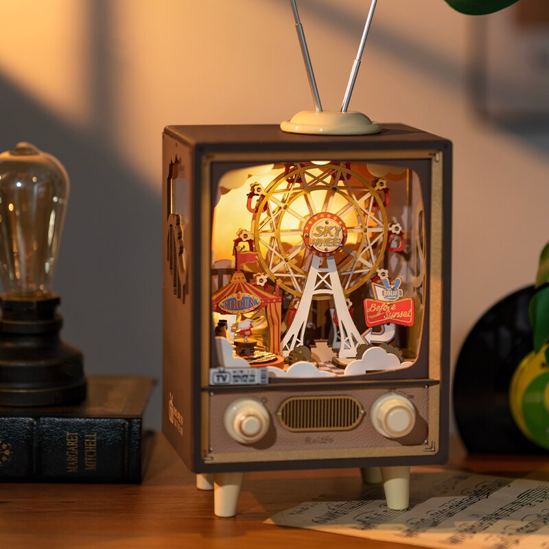 Music and light box with circus tent and ferris wheel in TV display lit up on shelf