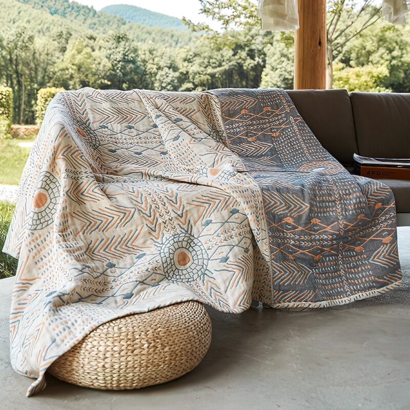 Cream throw blanket with abstract pattern of earthy blues and orange