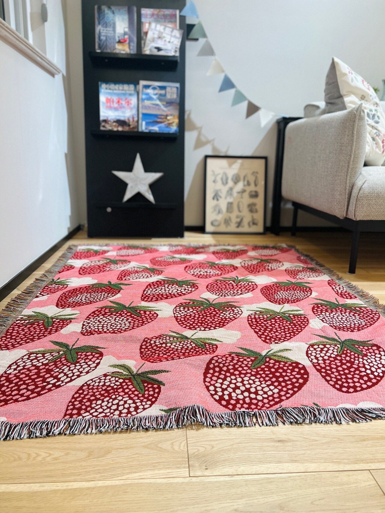 Strawberry blanket with fringe on floor