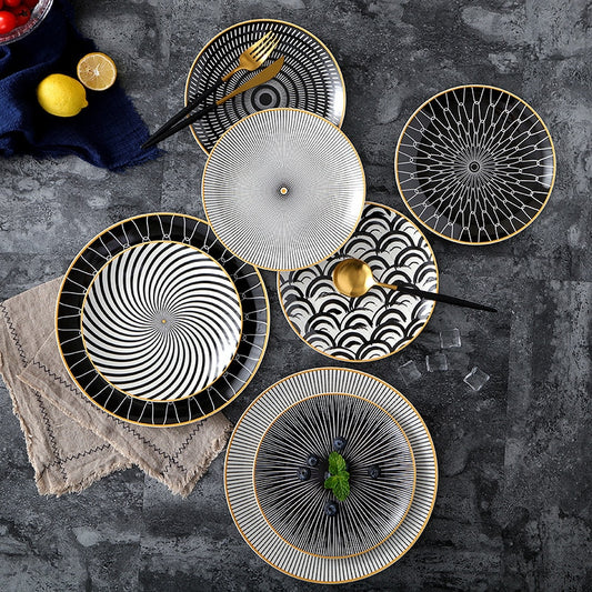 Black and white plates in various patterns with gold yellow edges