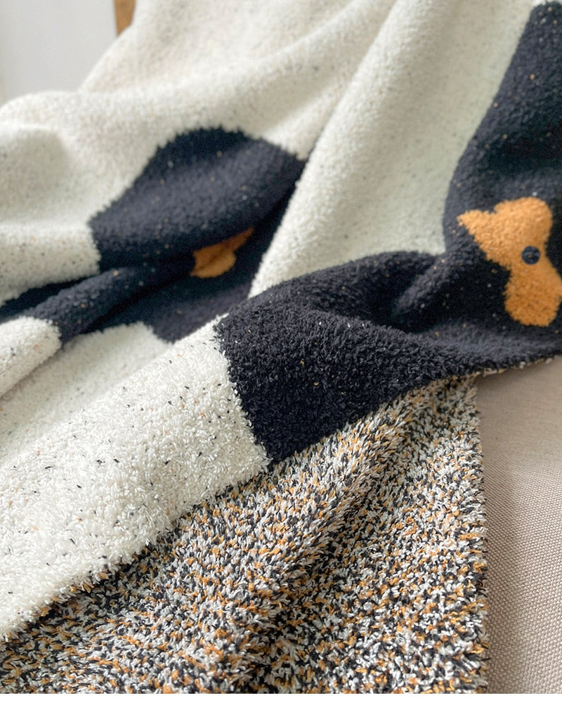 Soft knitted blanket close up black and amber flowers